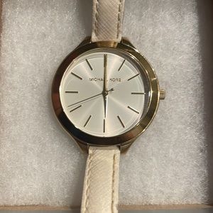 MK watch.gold stainless steel case with a white leather band. Used